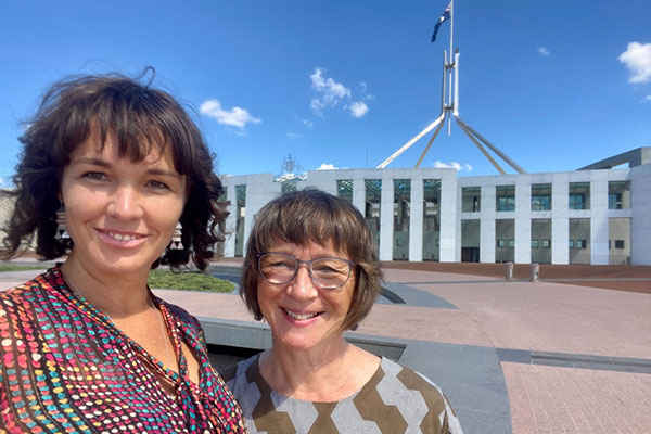 Renee Bowker and Carin Lavery stand in front of Parliament House in Canberra.
